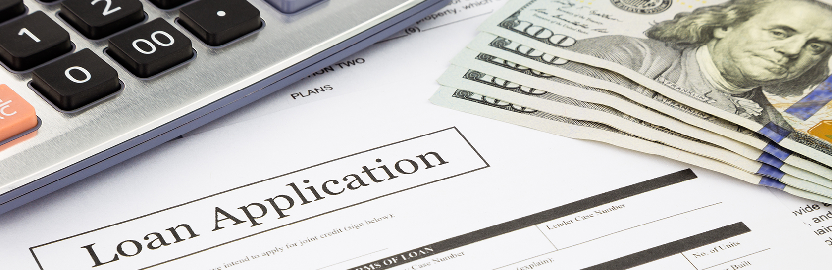 Stock photo of loan application with calculator and cash